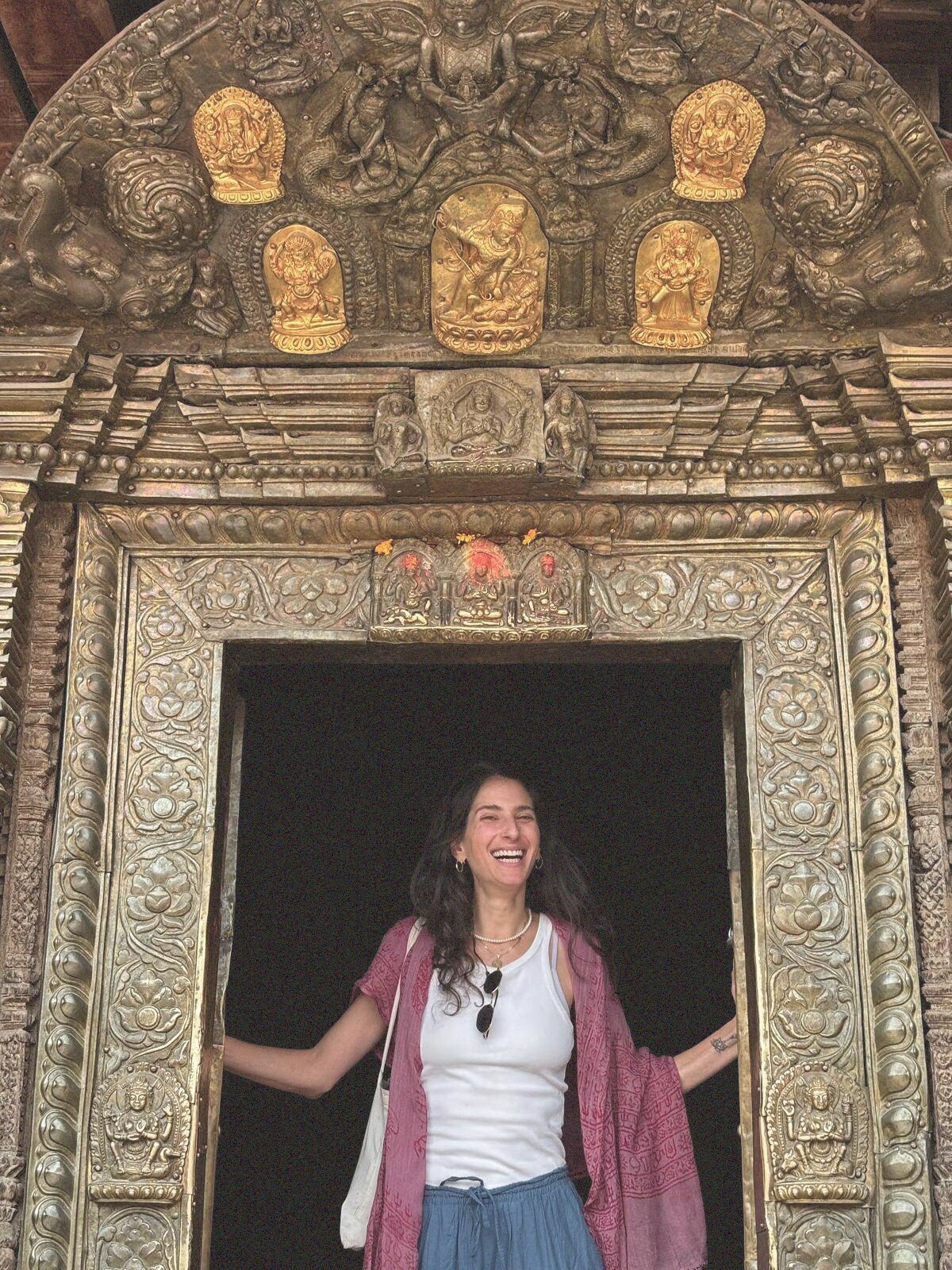 Stephania standing in a carved and gilded temple doorway