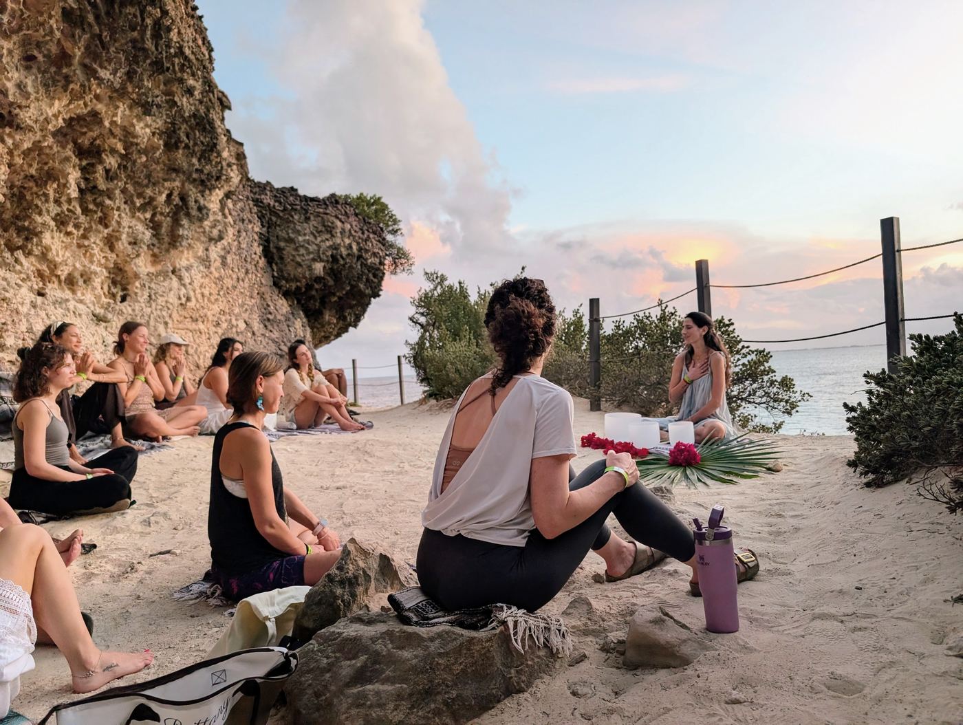 Students sitting together on the beach at sunset at the close of a training
