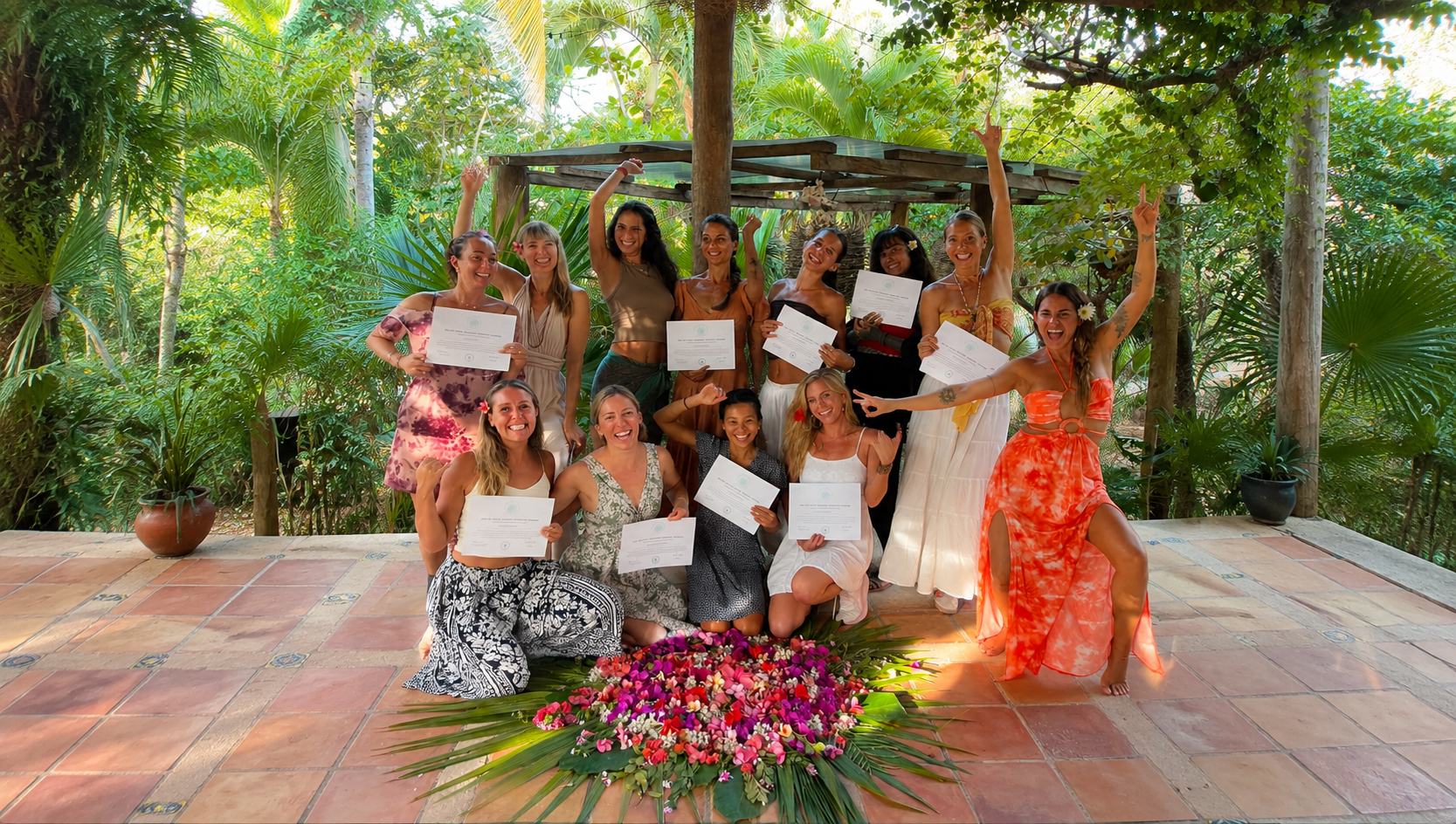 A graduating teacher training group holding their certificates